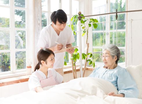 診察をする男性医師と訪問看護師